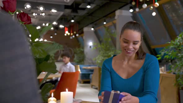 Excited Young Girl Millennial is Getting Gift From Boyfriend Feeling Happy and Smilinggratefully