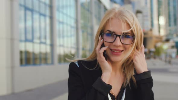 Beautiful Business Woman Blond In Glasses Walks Street Of The City alt
