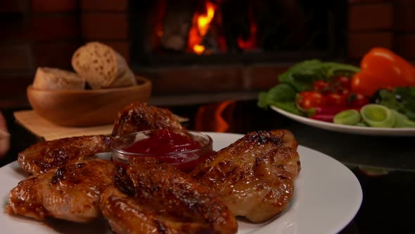 Chicken Wings and Ketchup Next To Burning Fireplace alt