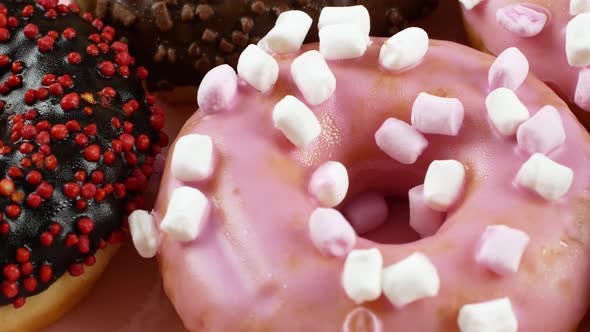 Close-up slider motion donuts. 4k closeup of delicious sweet multicolored donuts alt