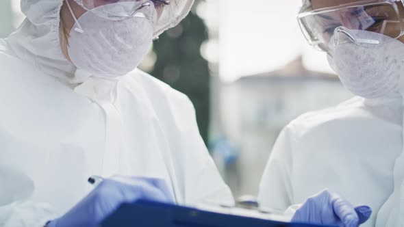 Tilt down of two technicians with clean suit. Shot with RED helium camera in 8K. alt