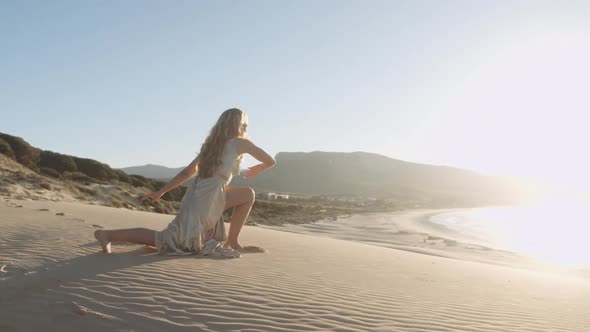Beautiful Woman Dancing In Gold On Beach alt
