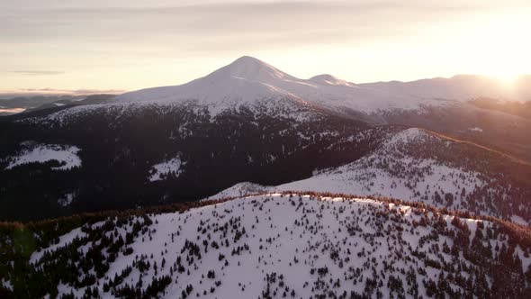 Aerial Panning Shot of Mountain Ridge with Sun Rising from Behind