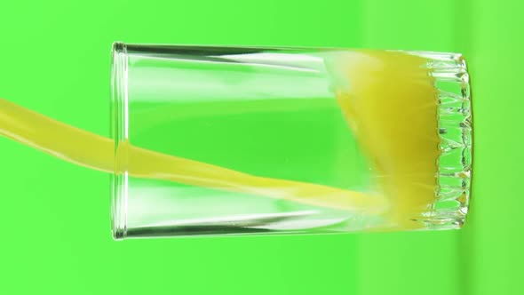 Vertical Video Juice Pouring Into Glass Isolated on Light Green Background