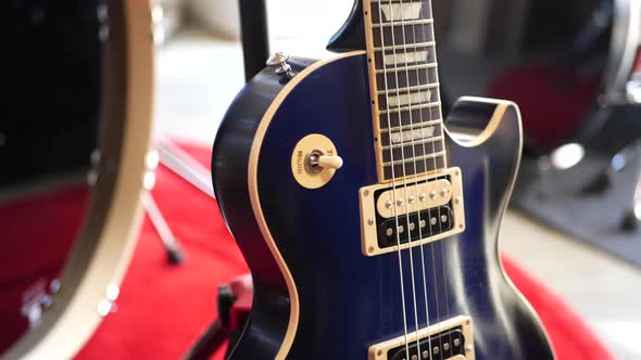 A vintage blue electric guitar on a concert stage in a rock and roll garage band setting. alt