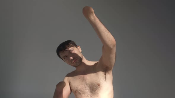 Man with Bare Torso and Amputated Hands Hides From Sunlight alt