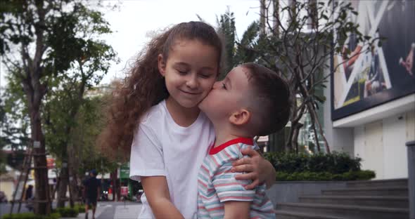 Children a Little Curly Girl Sister Are Hugging Her Brother alt