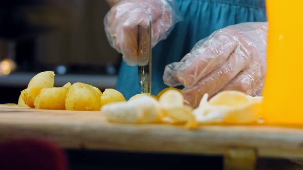 The Chef Cuts the Freshly Boiled Potatoes with a Professional Knife alt