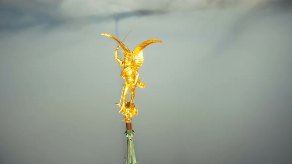 Extreme Aerial Close-up Shot of Heavenly Golden Saint Michael Angel Statue on Mont Saint Michel Sky alt