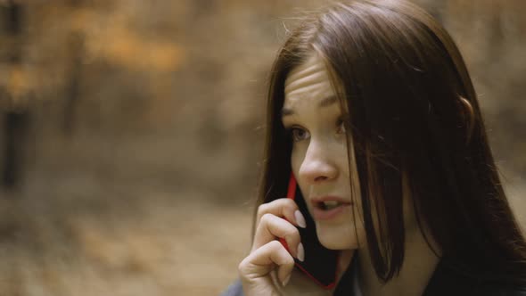 Woman with Long Hair Alone in Forest, Nervously, Tensely Talking on Mobile Phone