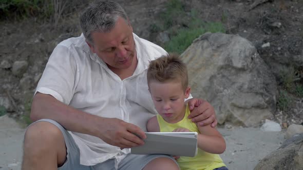 Grandson and Grandfather with Touch Pad Outdoor alt