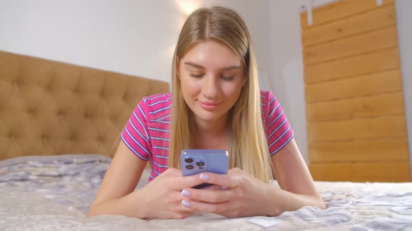 Cheerful young woman using modern smartphone for online communication with smile in 4k video alt