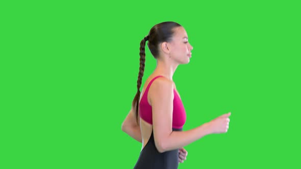 Beautiful Sporty Girl Running or Jogging on a Green Screen Chroma Key