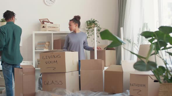 Young Couple Packing Things for Move alt