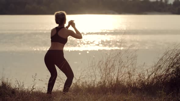 Fit Sporty Woman Squats Exercising At Sunset. Stretching Fitness Workout Activity. Squats Workout alt