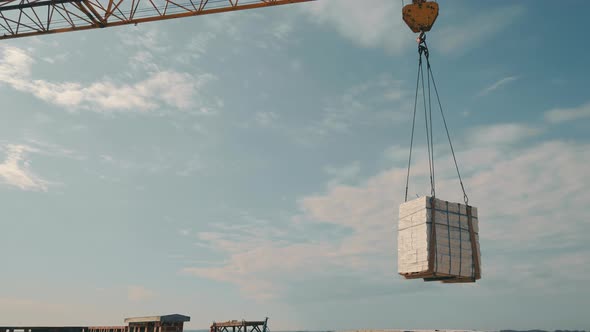 The Construction Crane Lifts the White Brick and Transfers It to the Construction Site alt