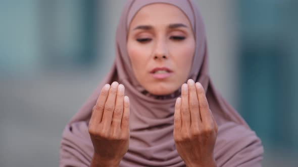 Close Up Female Face Serious Muslim Woman Wears Beige Hijab Traditional Clothing Praying Outdoors in alt