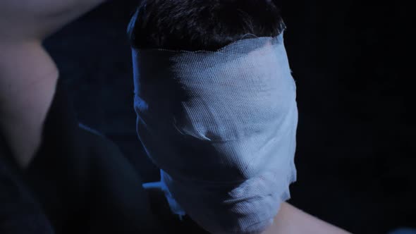 Man Taking Off Bandages From Head alt