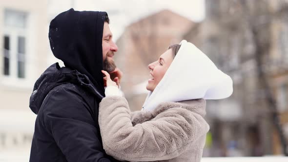Beautiful Man and Woman in the Winter on the Street Froze and Put on Hoods alt