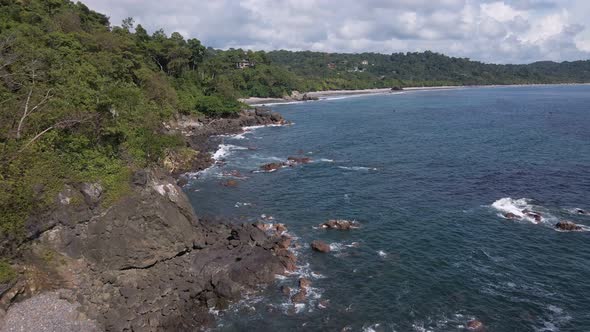 bird's eye view of the rocky coastline where the Pacific Ocean meets the shores of Costa Rica alt