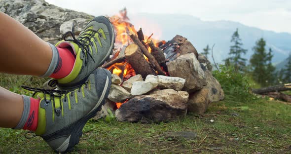 Female Hiker Rest Legs Near Campfire in Forest alt