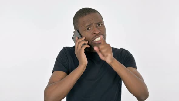 Angry Young African Man Talking on Phone on White Background alt