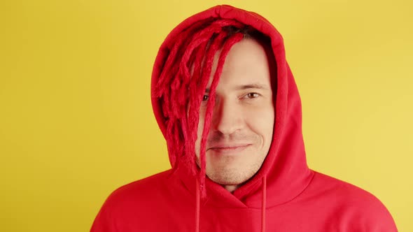Young Man with Red Dreadlocks in Hood Looking at Camera alt