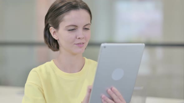 Young Woman Using Tablet Browsing Internet alt