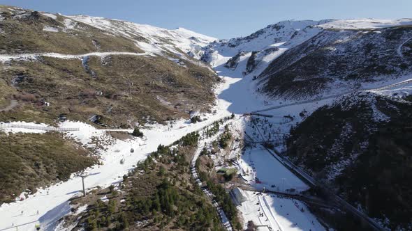 Aerial view of people skiing down slopes of Sierra Nevada ski resort, Spain