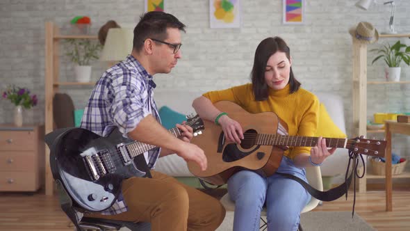 Young Man Guitarist Teaches a Young Woman To Play Guitar alt