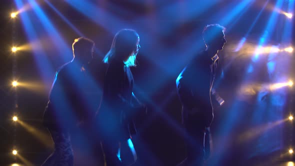 Silhouettes of a Talented Group Young Hip Hop Dancers. Hip Hop Street Dance on a Stage in Dark alt