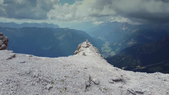 Flying Over Woman Raising Hands on the Top of Piz Boe Mountain in Dolomites alt