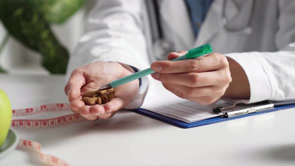 Almond Nuts Holds In Hand. Diet Nutritionist Tells The Benefits Of Almond Nuts. Consultation alt