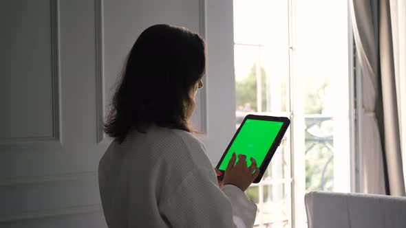 Woman Uses Tablet PC with Green Screen in Hotel alt