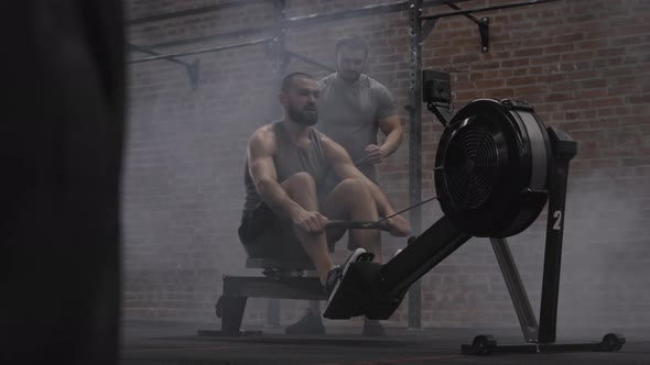 Sportsman Exercising on Exercise Machine in Gym alt