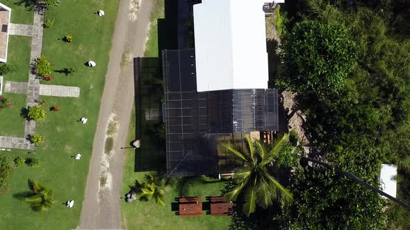Aerial rising shot over a local home on a beach BVI island Tortola. alt