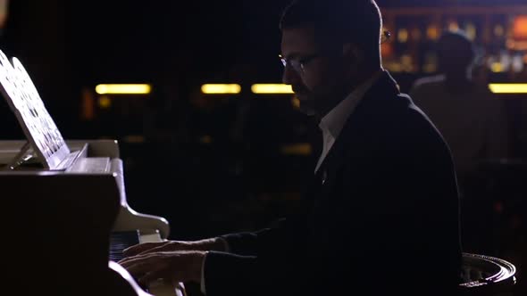 A pianist close up performing his own music on audience background