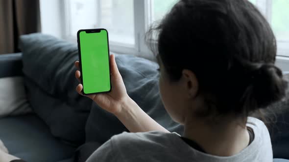 A Woman's Hand Holds A Smartphone With A Green Screen For Chromakey, Watches Social Networks