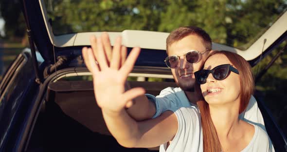 Couple Sitting in Car Trunk and Relaxing