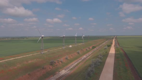 Aerial view of wind turbines energy production and road on fields