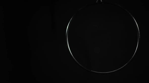 Redhead Slim Woman Hopping Down Leaving Air Hoop Spinning in Slow Motion at Black Background alt