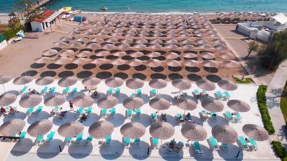 Flight Over the Beach with Umbrellas Towards the Pool in a Luxury Hotel alt