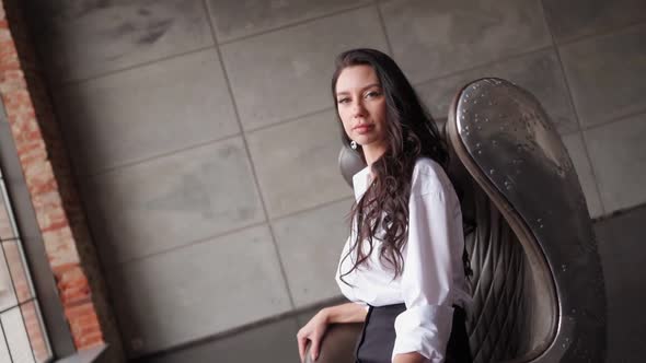 Confident Brunette Business Woman in White Shirt Looks at the Camera alt