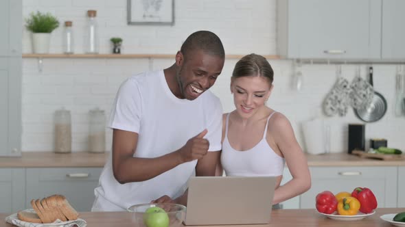 Sporty Woman and African Man Talking on Video Call in Kitchen alt
