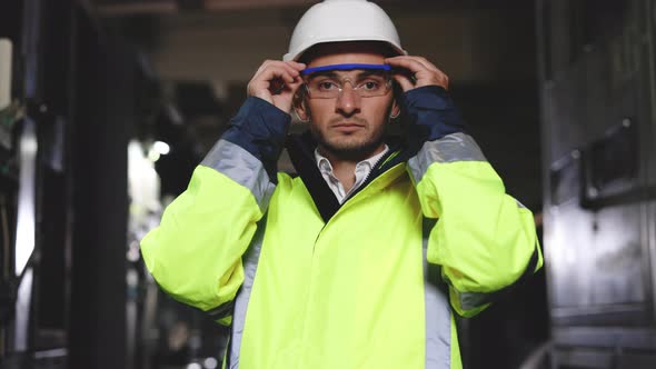Heavy Industry Engineer Worker Wearing Uniform Glasses and Hard Hat Looks at Camera