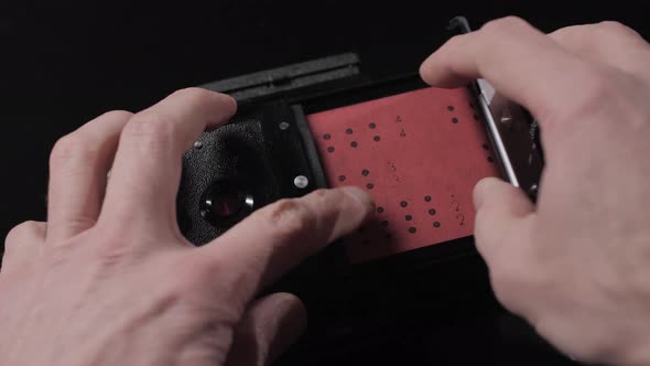 Vintage stereo photo camera on black background. Open rear door. Film inside. alt