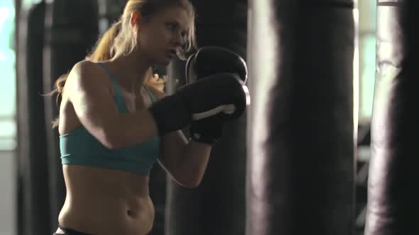 Woman does Muay Thai kickboxing training at the gym. alt