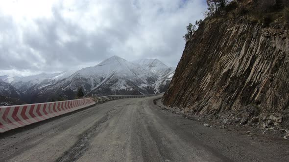 Off road car running on snowing mountain trail on winter day alt