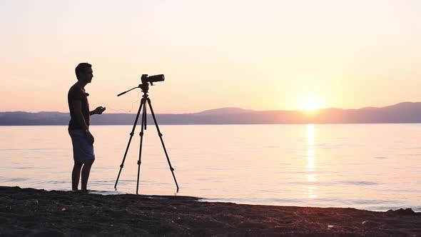 Silhouette Of A Young Man Enjoy Taking Video Of A Sunset In Lake Bracciano, Italy - Wide Shot alt
