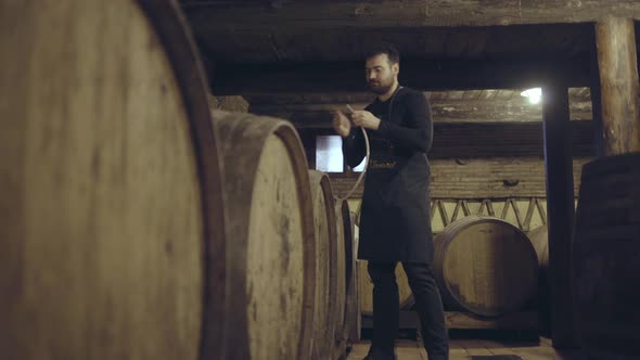 Farmer pouring wine from barrel